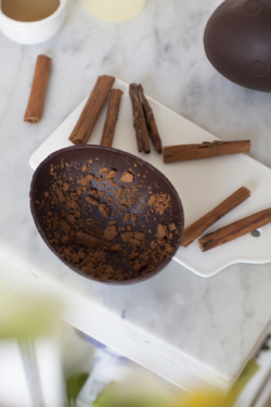 œuf Dandoy au chocolat fondant ouvert en deux, autour des bâtons de cannelle sur la table